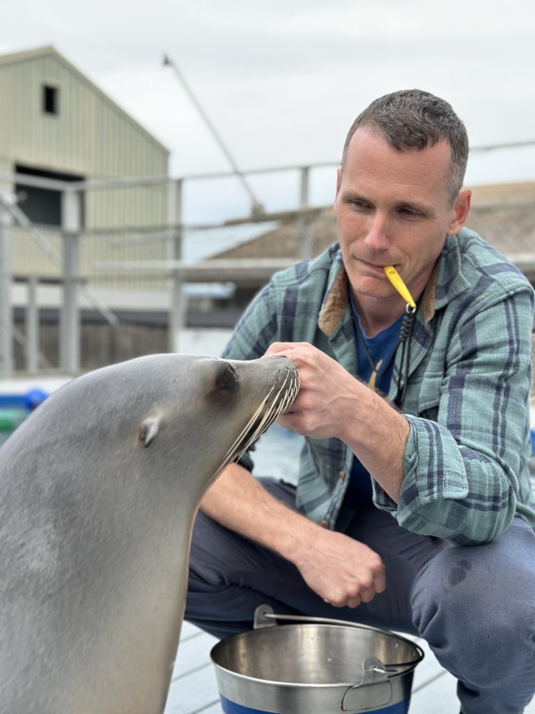 Portrait of Dr. Cook with handling a seal.