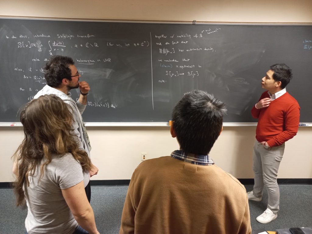 People in front of a chalkboard with math