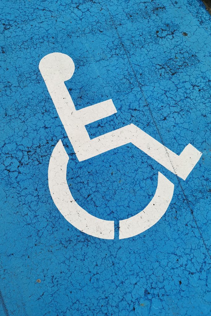 Parking space with wheelchair symbol on blue background for accessibility.